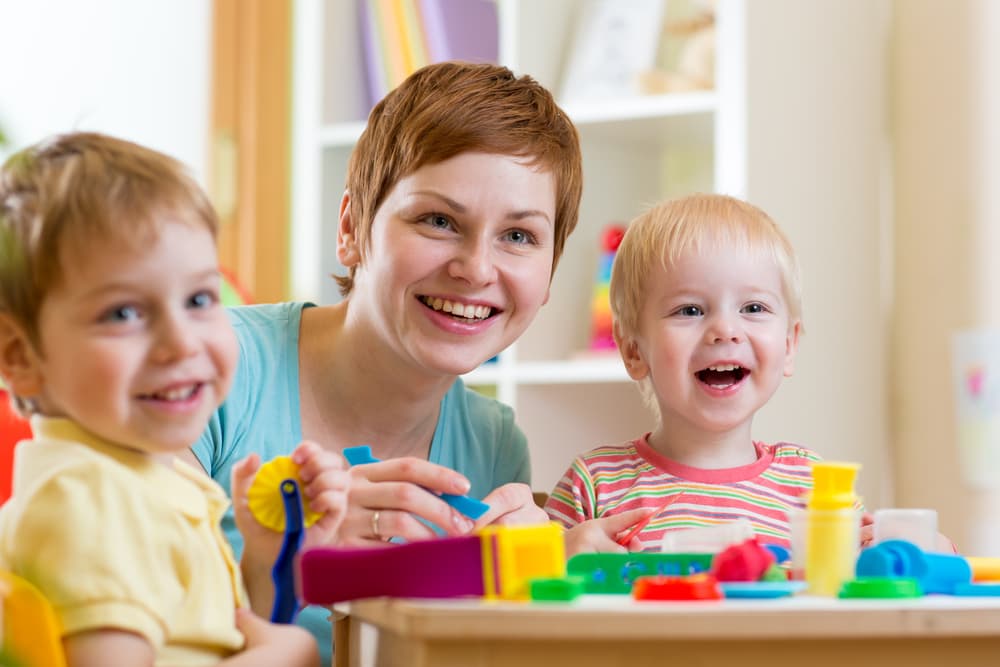 kidssmilingwiththeirdaycareteacher